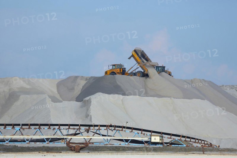 Dump truck unloading salt at a salt mine for salt extraction