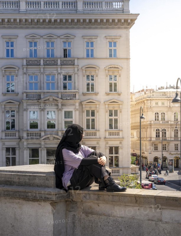 Tourist sitting on a balustrade
