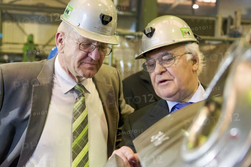 Minister President Winfried Kretschmann with Martin Herrenknecht - both wearing safety helmets - during a visit to Herrenknecht AG