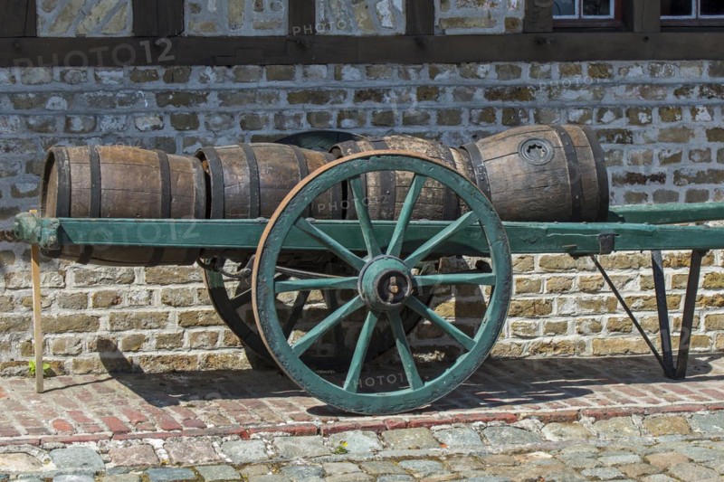 Antique handcart loaded with old wooden barrels