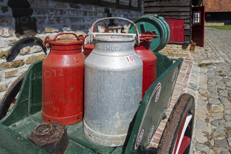 Antique handcart loaded with old metal milk churns