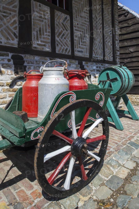 Antique handcart loaded with four old metal milk churns
