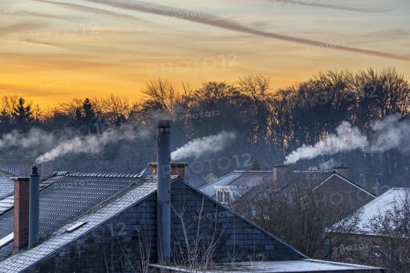 Smoking domestic rooftop chimneys from houses emitting vapour