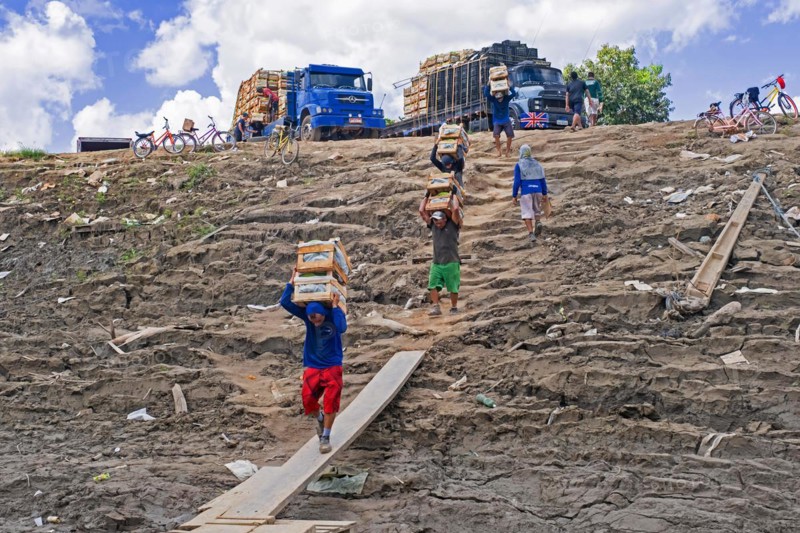 Manual labourers loading bananas from trucks to inland passenger and cargo vessel on the Amazon river at Porto Velho