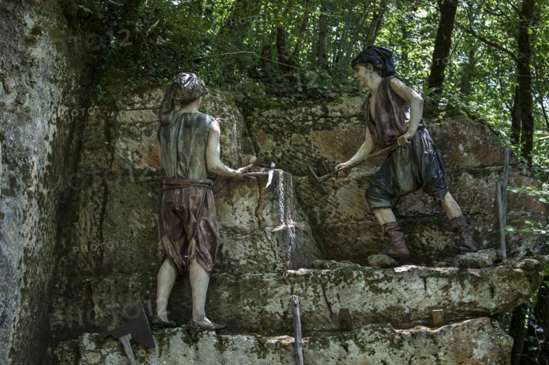 Diorama of medieval quarry workers cutting stones at the Grottes du Roc de Cazelle