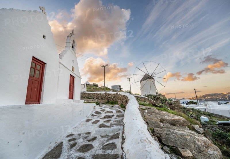 White Cycladic Greek Orthodox Twin Churches of Agios Antonios and Agios Nikolaos with Bonis Windmill at Sunrise