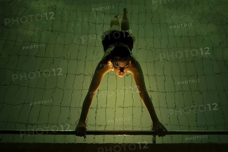 Woman Floating in a Illuminated Swimming Pool at Night in Switzerland