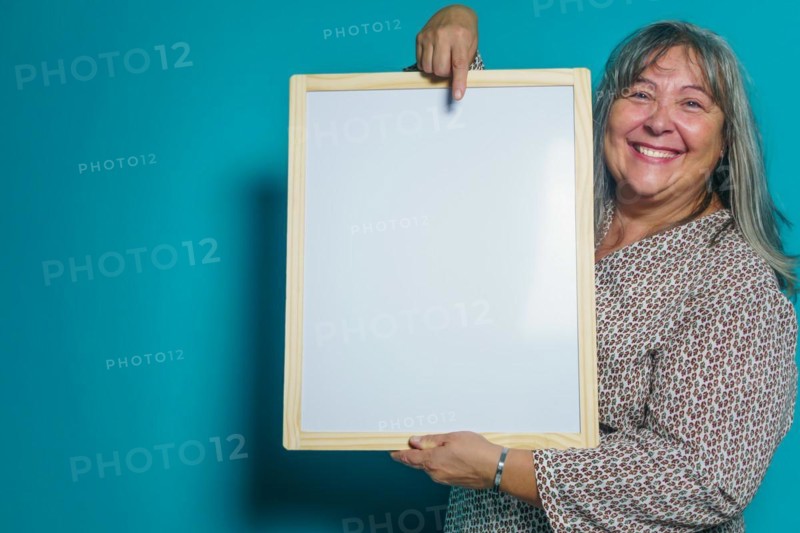 Older white-haired woman holding a white board to paste text on
