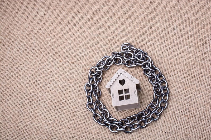 Metal chair around a model house on a linen canvas