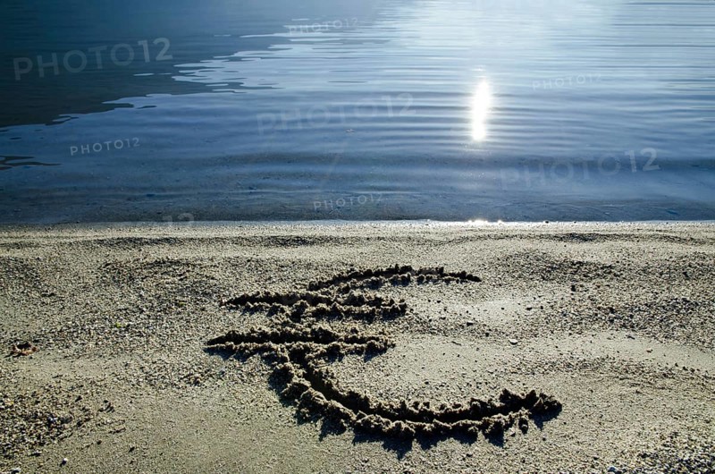 Euro Symbol on the Sand Beach with Sunlight