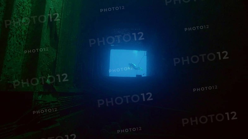 Scuba diver swims in blue water