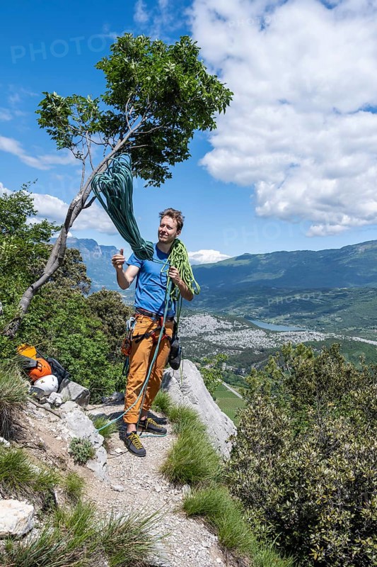 Climber throws climbing rope over his shoulder