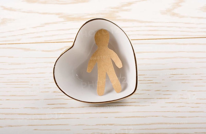Man shape cut out of paper in hand in the view