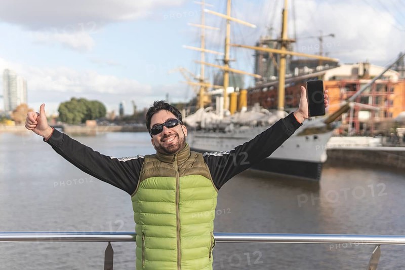 Happy tourist posing in front of a boat in Puerto Madero