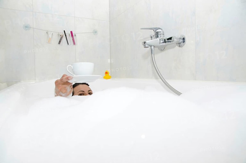 Woman Drinking a Coffee in the Bathtub with Foam