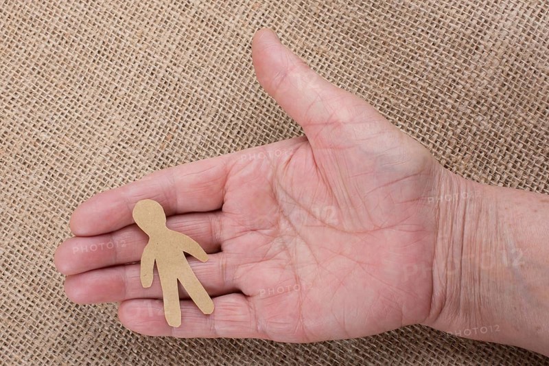 Man shape cut out of paper in hand in the view