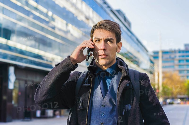 A handsome businessman talking on the cell phone near his office. Copy space