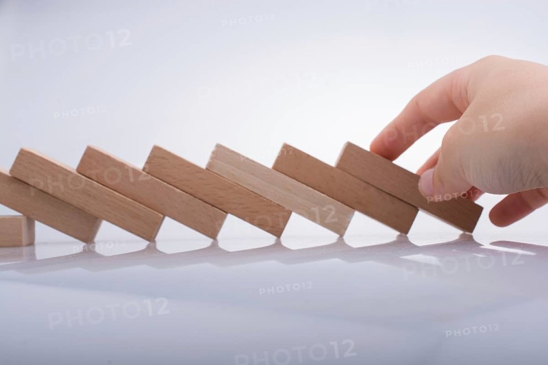 Hand holding wooden domino on a white background