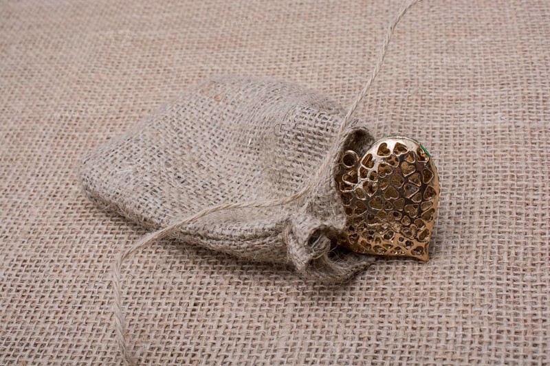 Heart shaped gold color metal object out of sack