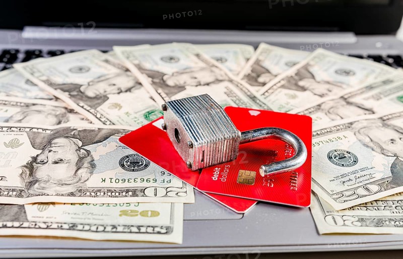 Close up of Padlock on top of credit card on dollar bills
