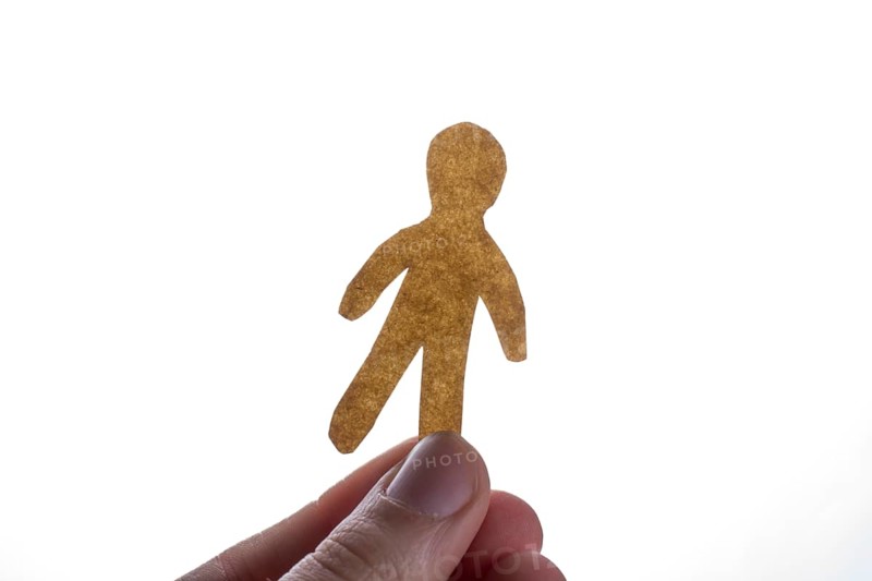 Man shape cut out of paper in hand in the view