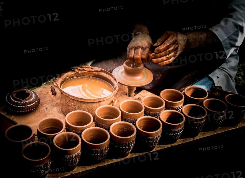 Potter`s hands shaping up the clay of the pot