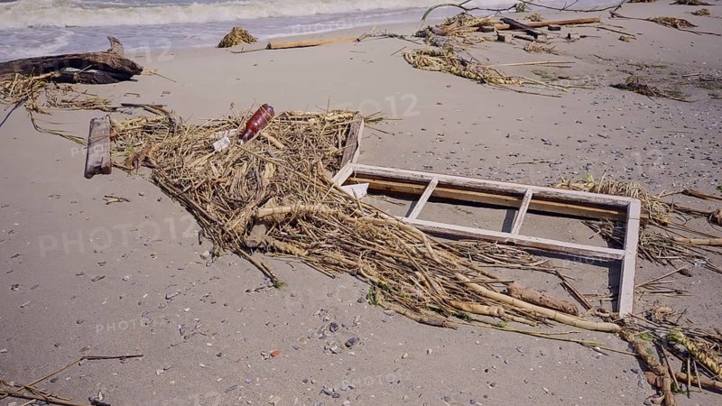 Window frame of house lies on sand