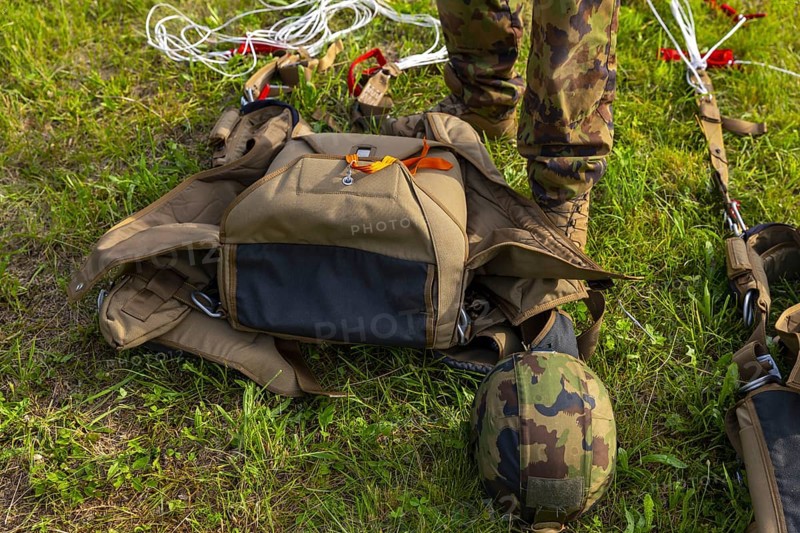 Military Parachuter Standing on the Grass with His Parachute in Switzerland
