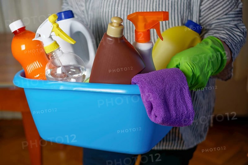 Woman holding a blue bucket with eco-friendly cleaning products.household cleaning concept