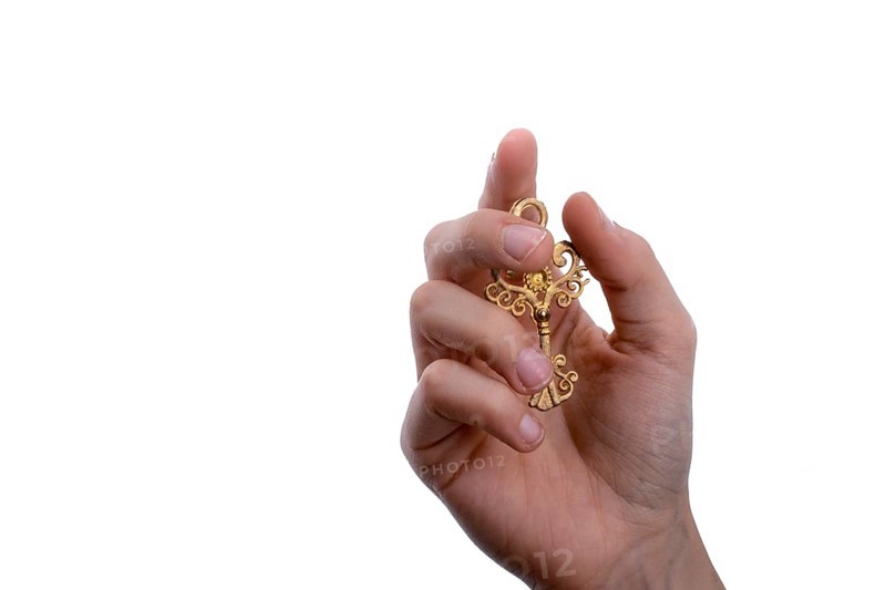 Hand holding a retro styled metal key on a white background