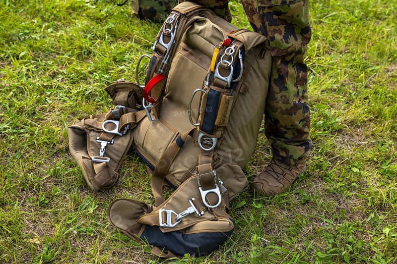 Military Parachuter Standing on the Grass with His Parachute in Switzerland