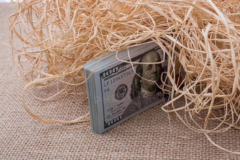 Banknote bundle of US dollar in a straw pile on canvas