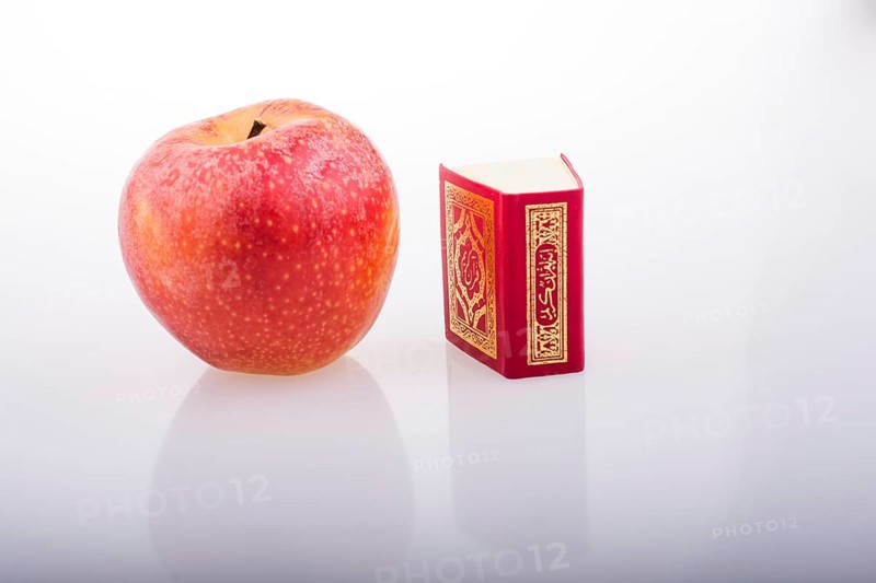Red apple and Islamic Holy Book Quran in mini size