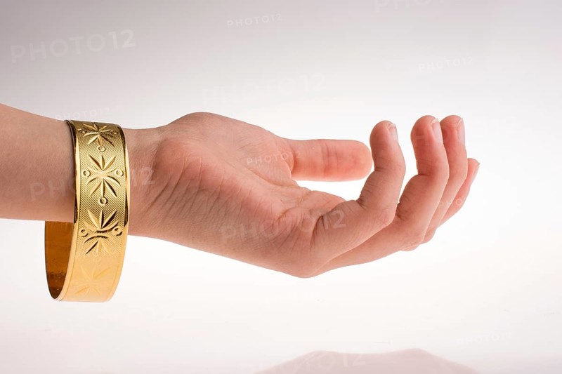 Hand with a golden bracelet on a white background
