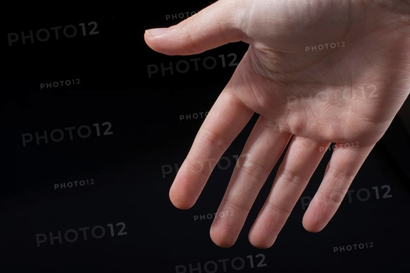 Five fingers of a child hand partly seen in black background