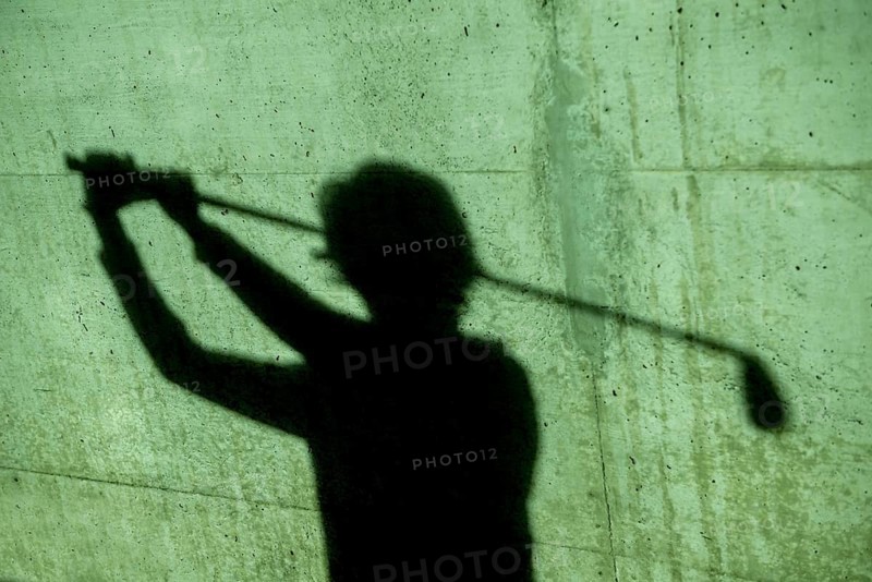 Shadow of a Golfer on a Wall Holding a Golf Club