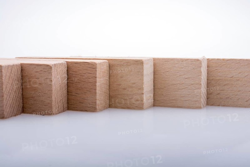 Wooden Domino Blocks in a line on a white background