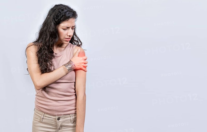Sore young woman with arm pain isolated. Woman suffering with arm pain
