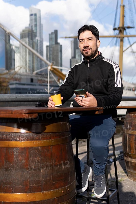 Latin tourist drinking coffee at an outdoor bar in Puerto Madero