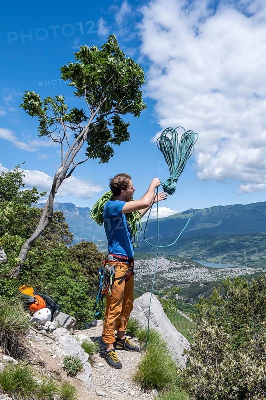 Climber throws climbing rope over his shoulder