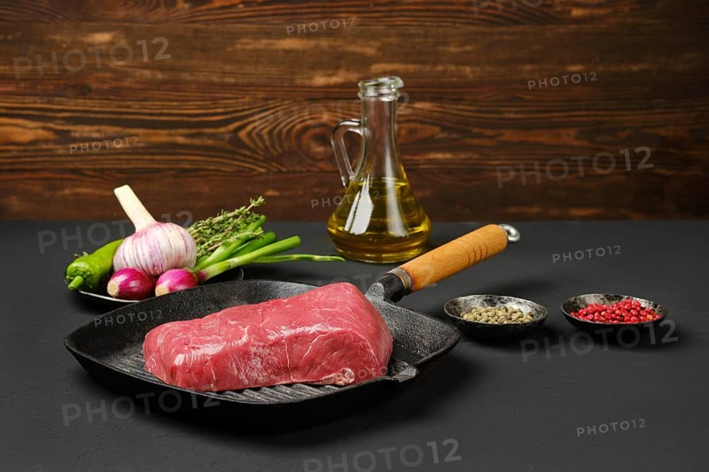 Uncooked beef steak boneless on cast iron skillet