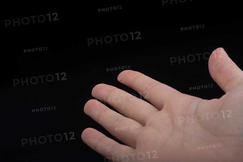 Five fingers of a child hand partly seen in black background