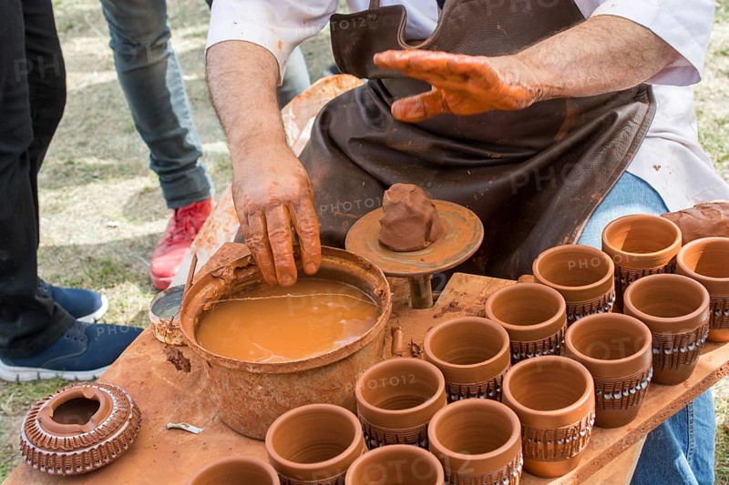 Potter`s hands shaping up the clay of the pot