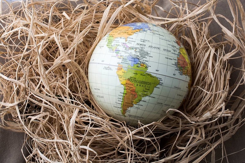 Little model globe is put on a straw background
