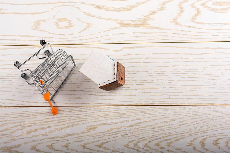 Little model house and a trolley and on a parquet background