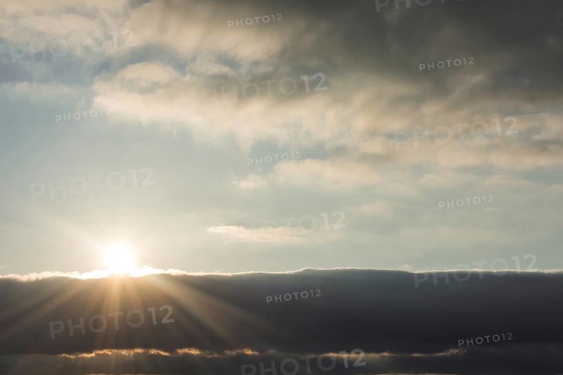 Sun behind beautiful white clouds in midday
