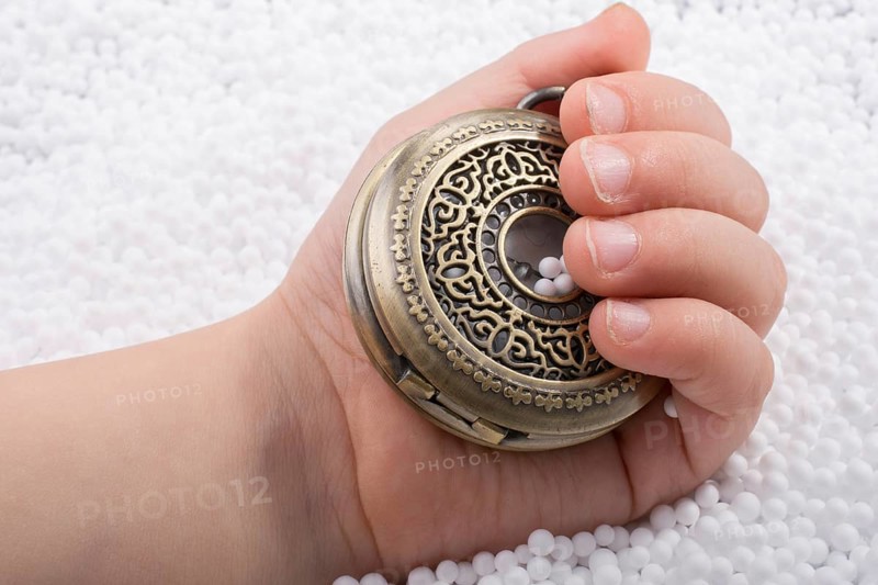 Retro style pocket watch in hand on white background
