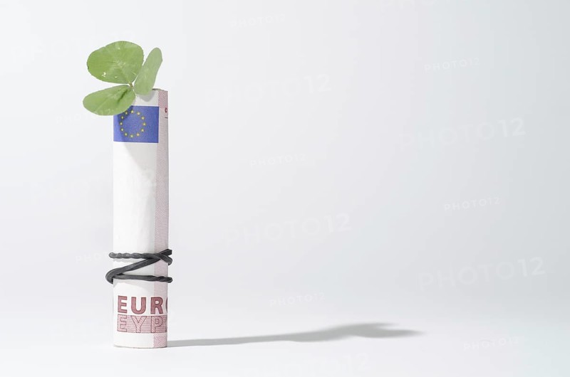 The Bill of Rolled Ten Euro with Three Leaf Clover and Rubber Band with Shadow