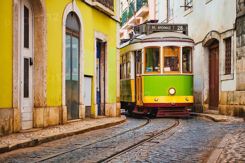Famous vintage yellow tram 28 in the narrow streets of Alfama district in Lisbon