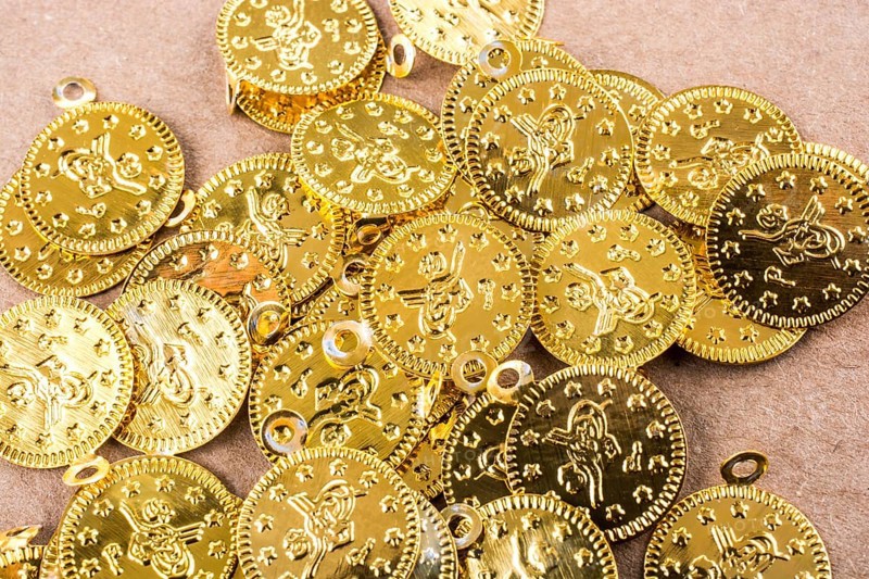Spiral notebook and the gold coins on white background
